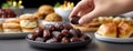 Hand reaches for dates in a bowl, capturing a moment of togetherness during a festive iftar dinner in Ramadan Royalty Free Stock Photo