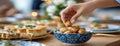 Hand reaches for dates in a bowl, capturing a moment of togetherness during a festive iftar dinner in Ramadan Royalty Free Stock Photo