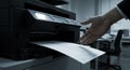 Printing Document in Office with Modern Printer and Hand Reaching Royalty Free Stock Photo