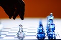 Hand Reaches for Strategically Lonely Glass Chess Royalty Free Stock Photo