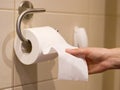 Hand reaches for toilet paper Royalty Free Stock Photo