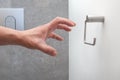 A hand reaching for an empty toilet paper holder Royalty Free Stock Photo