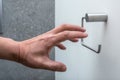 A hand reaching for an empty toilet paper holder Royalty Free Stock Photo