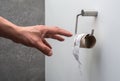 A hand reaching for an empty toilet paper holder Royalty Free Stock Photo