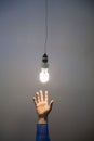 Hand reaching for light bulb Royalty Free Stock Photo