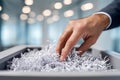 Hand reaching into a modern office paper shredder filled with shredded documents symbolizing data security and confidential Royalty Free Stock Photo