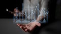Hand Reaching Out with Digital Graph and Data Visualization Displaying Financial Growth Trends in a Modern Business Royalty Free Stock Photo
