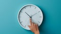 hand reaching out to a white wall clock on a light blue background, seemingly to adjust the time..AI generated image Royalty Free Stock Photo