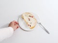 Hand reaching for a piece of bread on a plate Royalty Free Stock Photo