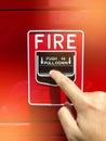 A hand reaching and pulling a red fire alarm switch. red fire alarm Royalty Free Stock Photo