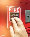 A hand reaching and pulling a red fire alarm switch. red fire alarm Royalty Free Stock Photo