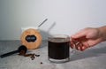 Hand reaching to a glass of black coffee and, bowl with stevia sweetener in the background Royalty Free Stock Photo