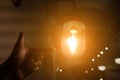 Hand reaching for a vintage light bulb. Royalty Free Stock Photo