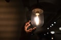 Hand reaching for a vintage light bulb. Royalty Free Stock Photo