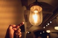 Hand reaching for a vintage light bulb. Royalty Free Stock Photo