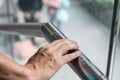 Hand reading Braille inscriptions for the blind on public amenity railing Royalty Free Stock Photo