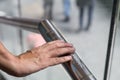 Hand reading Braille inscriptions for the blind on public amenity railing Royalty Free Stock Photo