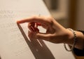 Hand Reading Braille Text by Touch with Ring and Bracelet in Macro Close-Up Royalty Free Stock Photo