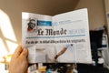 Hand reading le monde newspaper on euthanasia debate cover