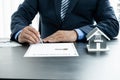 The hand of the real estate agent, holding a pen and drafting an agreement on the home insurance contract documents, along with Royalty Free Stock Photo