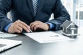 The hand of the real estate agent, holding a pen and drafting an agreement on the home insurance contract documents, along with Royalty Free Stock Photo