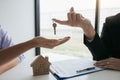 Hand of real estate agent passes the key to new homeowners in office with buyer house concept Royalty Free Stock Photo