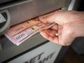 Hand receiving cash money from ATM machine
