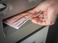Hand receiving cash money from ATM machine