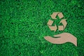 Hand and recycle symbol paper cut on green grass background with copy space , green energy iconic symbol Royalty Free Stock Photo