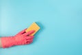 A hand in a red glove wipes the wall from dust with a yellow sponge Royalty Free Stock Photo