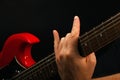 Hand with red guitar and devil horns on black Royalty Free Stock Photo