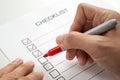 Hand with red marker pen marking on checklist box Royalty Free Stock Photo