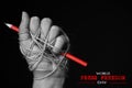 Hand with red pencil tied with rope