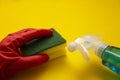 Hand in red rubber glove with a sponge and liquid detergent