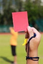 Hand of referee with red card and whistle Royalty Free Stock Photo