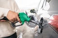 Hand refilling the car with fuel at the refuel station. Grey car at gas station being filled with fuel at New Zealand. Handle fuel Royalty Free Stock Photo