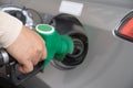 Hand refilling the car with fuel at the refuel station. Grey car at gas station being filled with fuel at New Zealand. Handle fuel Royalty Free Stock Photo