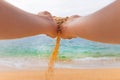 hand releases the falling sand. Fine sand flows through your fingers against the backdrop of the sea. Summer beach Royalty Free Stock Photo