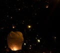 hand releasing a Chinese lantern into the air at night thousands of flying lanterns. Christmas Royalty Free Stock Photo