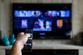 Hand with a remote control. Whats on tv, sliding through apps en movies on your television Royalty Free Stock Photo
