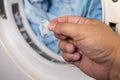 Hand removing lint from fabric trapped on laundry dryer filter Royalty Free Stock Photo