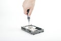 Hand repairman unscrews the cover of the engine of the open 3.5 inch HDD with a screwdriver. Royalty Free Stock Photo