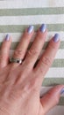 Hand with ring and purple nail polish. Beauty fashion photo.