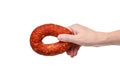 Hand with a ring of tasty smoked sausage on a white background Royalty Free Stock Photo