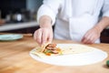 hand rolling peking duck in a thin pancake