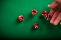 Hand rolling red dices on table