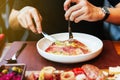 Hand rotate the shaft of the fork, twining the strands of pasta around the tines for eating Fettuccine Carbonara with parma ham. Royalty Free Stock Photo