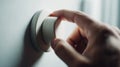 Hand adjusting a dimmer switch, decreasing light output. Promoting energy saving, smart home management, and comfortable ambiance Royalty Free Stock Photo