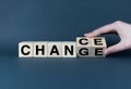 Hand rotating a wooden block to transform the word change into chance
