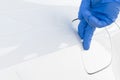 Hand in rubber glove closes gasoline tank lid in the car, closeup